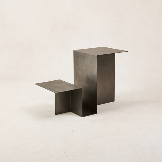 Minimalist metal nesting tables with a geometric design against a neutral background.
